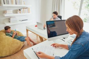 a family sit together in their home office making use of social networking and computer technology