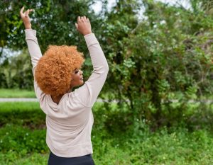 Woman outside celebrating with hands up