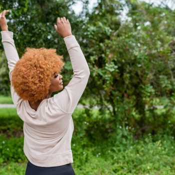 Woman outside celebrating with hands up