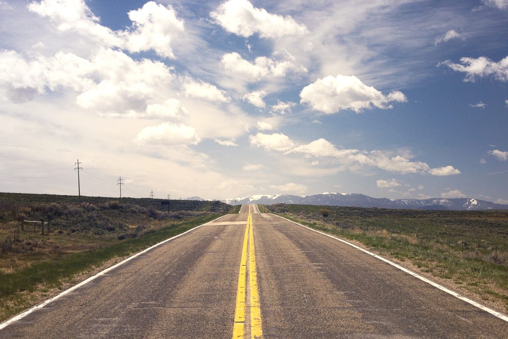 photo showing blue skies and a long endless road