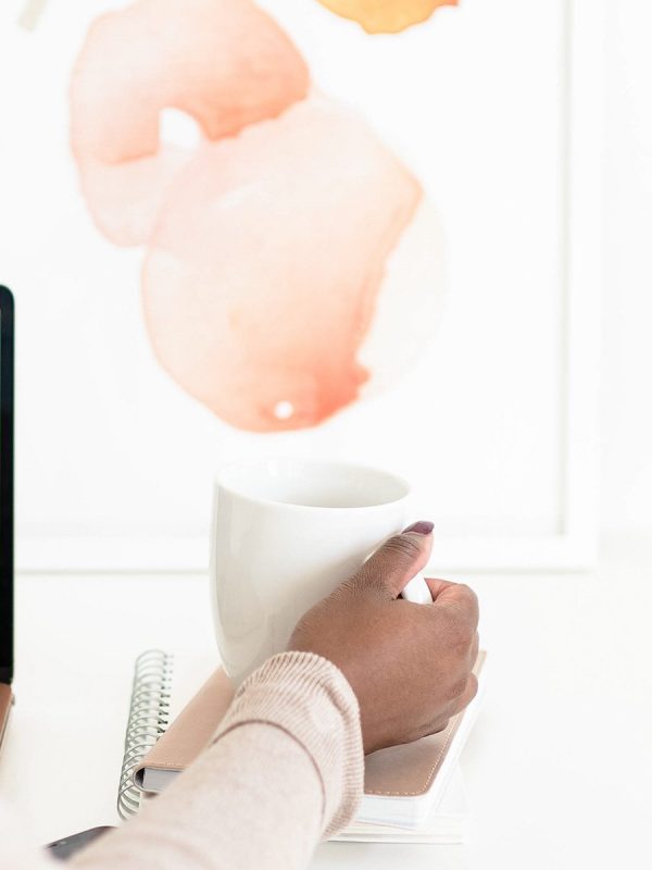 Women Holding Coffee Mug In front of computer screen