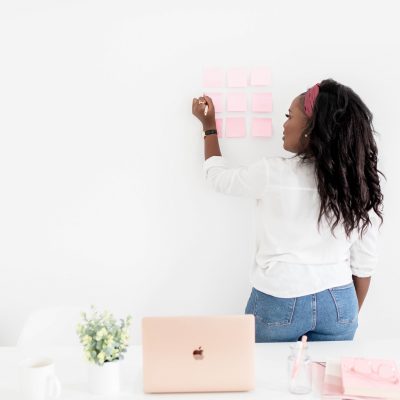 Woman Planning Cyber Security & Digital Well-Being Strategies on sticky notes placed on whiteboard